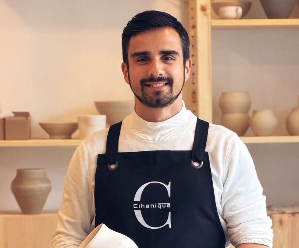 Cihanique logosu baskılı siyah önlük giyen gülümseyen usta